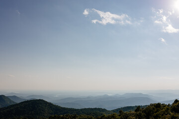 Obraz premium Beautiful mountain landscape from a bird's eye view of a blue mountain, endless horizon and trees in the foreground. Sassafras Mountain, South Carolina 29635, USA