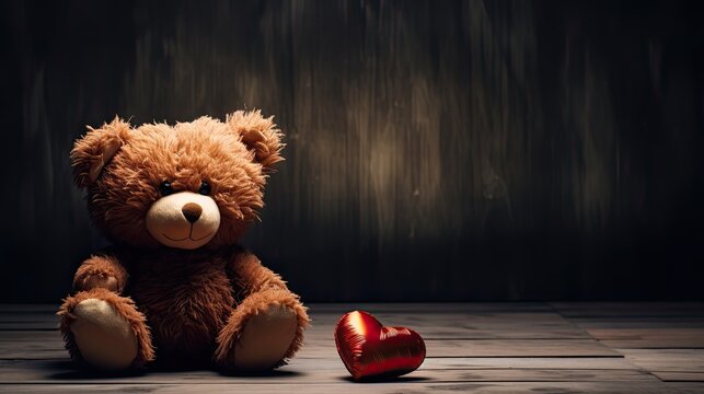 A teddy bear sitting on a floor with a dark and brown