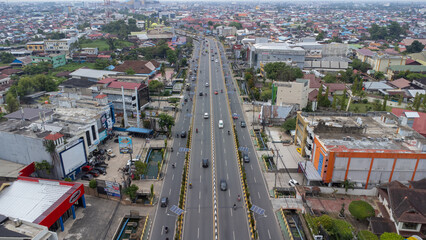 The long flyover in Banjarmasin is passed by many cars and motorbikes