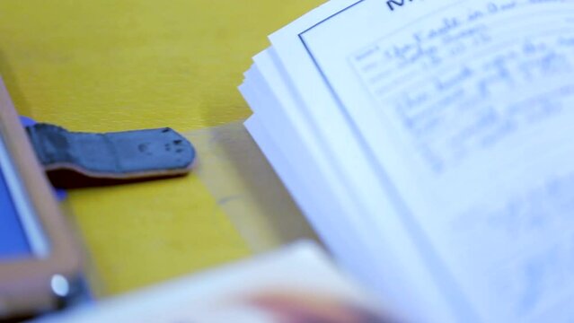 Side-to-side panning close-up of handwritten recommendations in a workbook placed on a yellow desk &mdash; perfect for academic, workplace, or learning visuals.