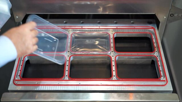 Production of plastic packages, industrial background. Media. Close up of conveyor belt with plastic small boxes.