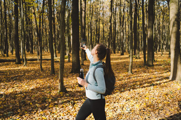 Beautiful girl uses phone for fitness or yoga. Body positive, sports for women, harmony, healthy lifestyle, self-love and wellness.