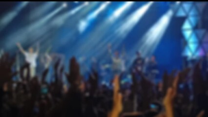 Defocused Abstract Background of Cheering concert crowd with colorful stage light, silhouette of Large group of people audience at live music festival