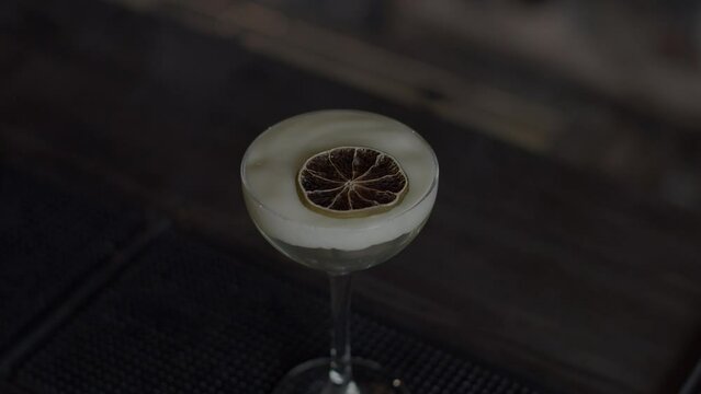 Close up of cocktail with a slice of dried orange fruite in smoke. Media. Concept of party at a bar or night club.