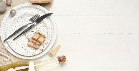 Beautiful table setting with Christmas gifts, champagne and decorations on white wooden background with space for text