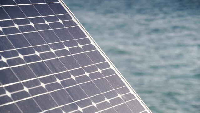 Portable solar panel, photovoltaic cell working outdoors on seashore. Renewable free energy.