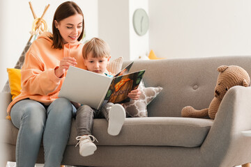 Nanny reading story to little boy at home