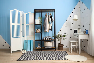 Interior of dressing room with shelving unit, clothes and table