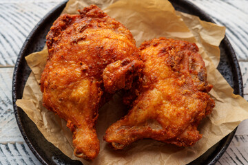 Crispy chicken thighs fried on a wooden table