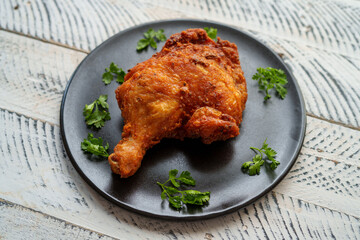 Crispy chicken thighs fried on a wooden table