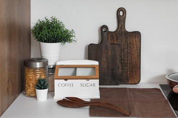 Cutting boards with food, utensils and plants on counter in kitchen