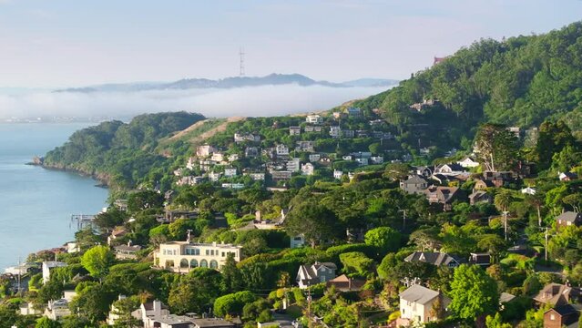 Aerial view of Sausalito landscape with cute houses at the Pacific Ocean, San Francisco area, California, West coast, USA. Breathtaking shot of San Francisco suburban with Golden Gate bridge in fog