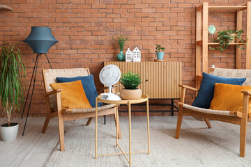 Interior of stylish living room with electric fan on coffee table