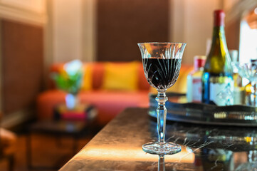 A glass of red wine on beverage counter for enjoy drinking in the room at home.