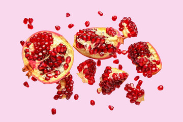 Flying fresh pomegranates with seeds on lilac background