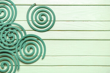 Mosquito spirals on green wooden background