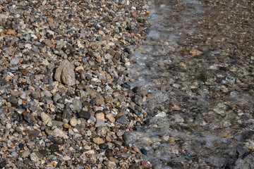 colorful pebbles and waves on the seashore