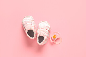 Stylish baby shoes with pacifier on pink background - obrazy, fototapety, plakaty