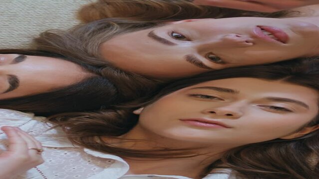 Girls touching perfect skin top view closeup. Three models lying bed vertically 