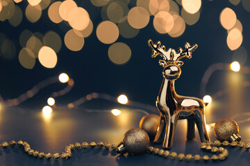 Christmas golden deer with decorations on dark background