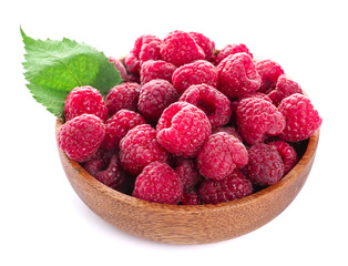 Wooden bowl with fresh ripe raspberries and leaf on white background
