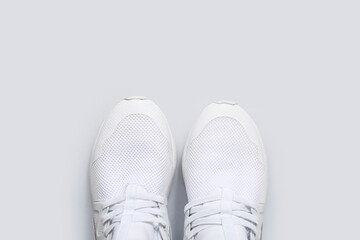 Stylish white sneakers on grey background
