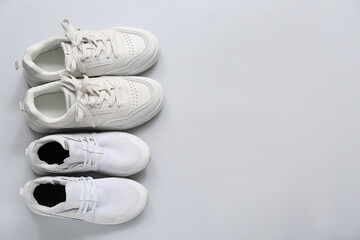 Stylish white sneakers on grey background