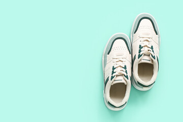 Stylish sneakers on turquoise background