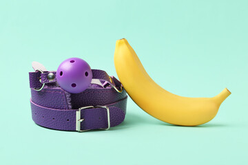 Sex toys and tasty banana on turquoise background