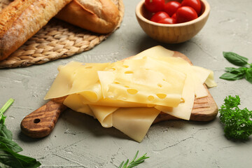 Board with tasty cheese slices, tomatoes and bread on light background, closeup