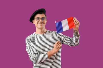 Young man with flag of France on purple background