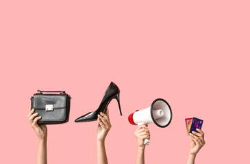 Female hands with women accessories, megaphone and credit cards on pink background. Black Friday sale