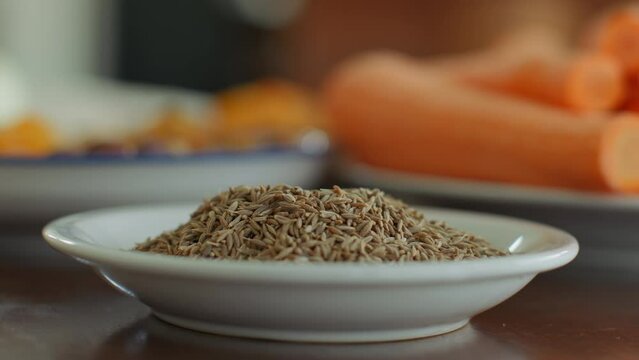 Seasoning for cooking brown cumin is in a white saucer. The plate is filled to the brim with seasonings and is ready to prepare dinner. A juicy picture of the seasoning the chef uses.