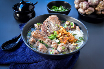 Thai food, Rice soup with  Minced pork and pork ribs on a black background 