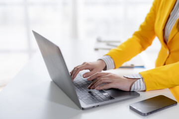 Close-up of hand of businesswoman working using laptop computer.