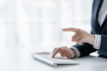 Close-up hand woman typing keyboard on laptop computer and finger pointing.