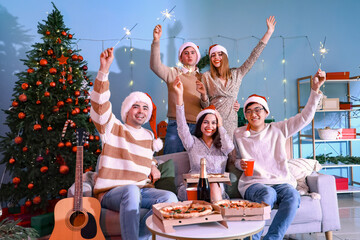 Group of young friends with Christmas sparklers at home party