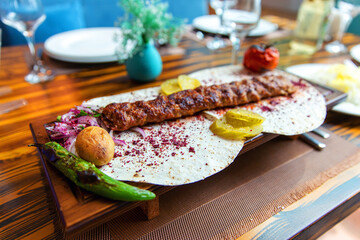 Traditional Caucasian appetizing kebab served with pickled cucumbers, stewed tomato and hot peppers...