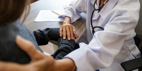 Senior woman doctor wear white medical uniform holding hand of female patient having disease health...