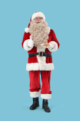 Santa Claus with tasty falafel balls showing thumb-up on blue background