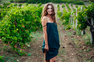 Fototapeta premium woman in green dress in vineyard walk