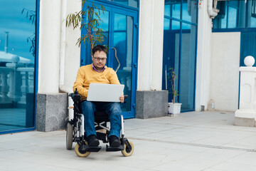 a person with disabilities near the building with a laptop