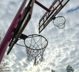 Basketball hoop against the background of the sky with clouds