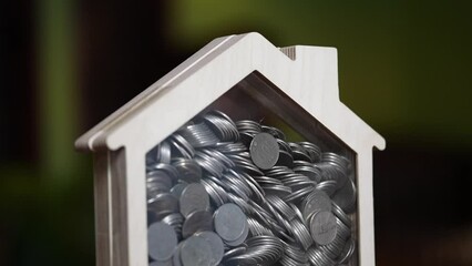 Coins in a house model's piggy bank