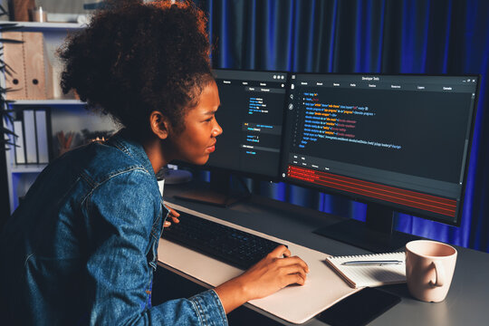 Young African IT professional developer wearing jeans shirt cheeking cyber code, concentrate on laptop screen, display data of application and website, create innovative updated version. Tastemaker.