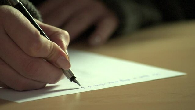 Close-up of fountain pen writing in an old-fashioned paper notebook or diary
