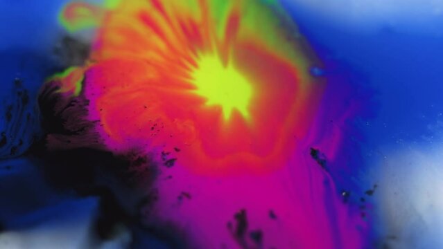 Paint drop. Ink spatter in water. Acrylic dye blotch. Defocused bright neon magenta pink blue yellow black color gradient fluid mix wave flow motion abstract art background.