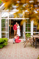 Beautiful and happy family on the porch of the house. 