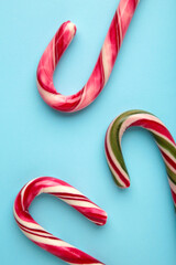 Christmas candy cane on blue background. Top view