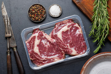 Raw ribeye steaks with savory spices